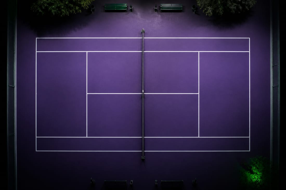 A tennis court photographed from directly overhead showing baselines, sidelines, service boxes, centre service line and centre mark