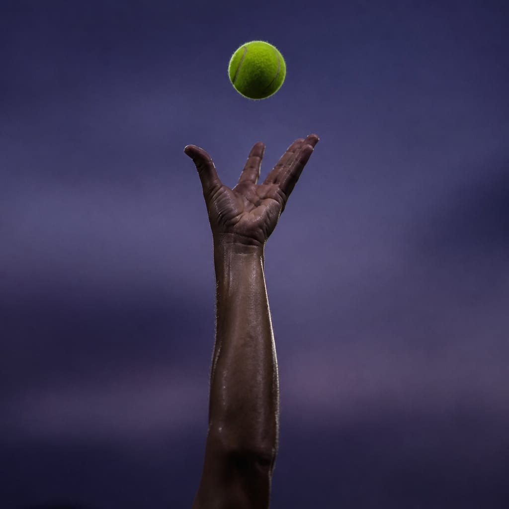 A tossing hand at the moment of release with the fingers opening flat and the ball just leaving the fingertips