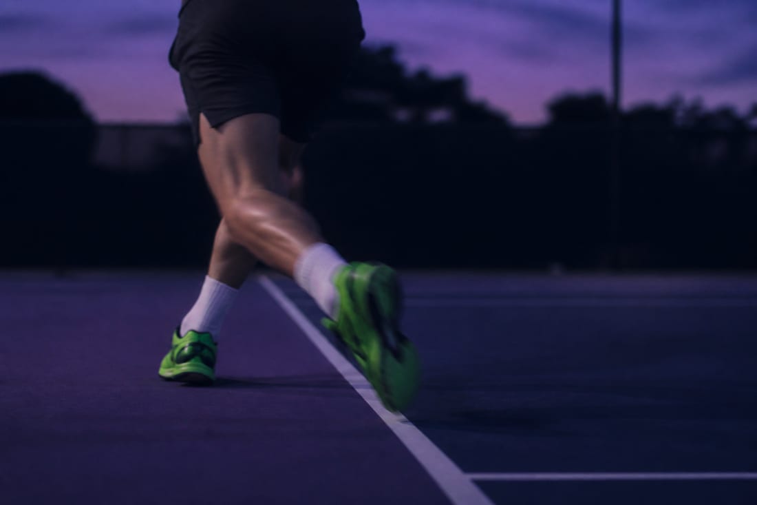 A player mid-crossover step moving wide, the trailing leg crossing behind the lead leg with the hips turned